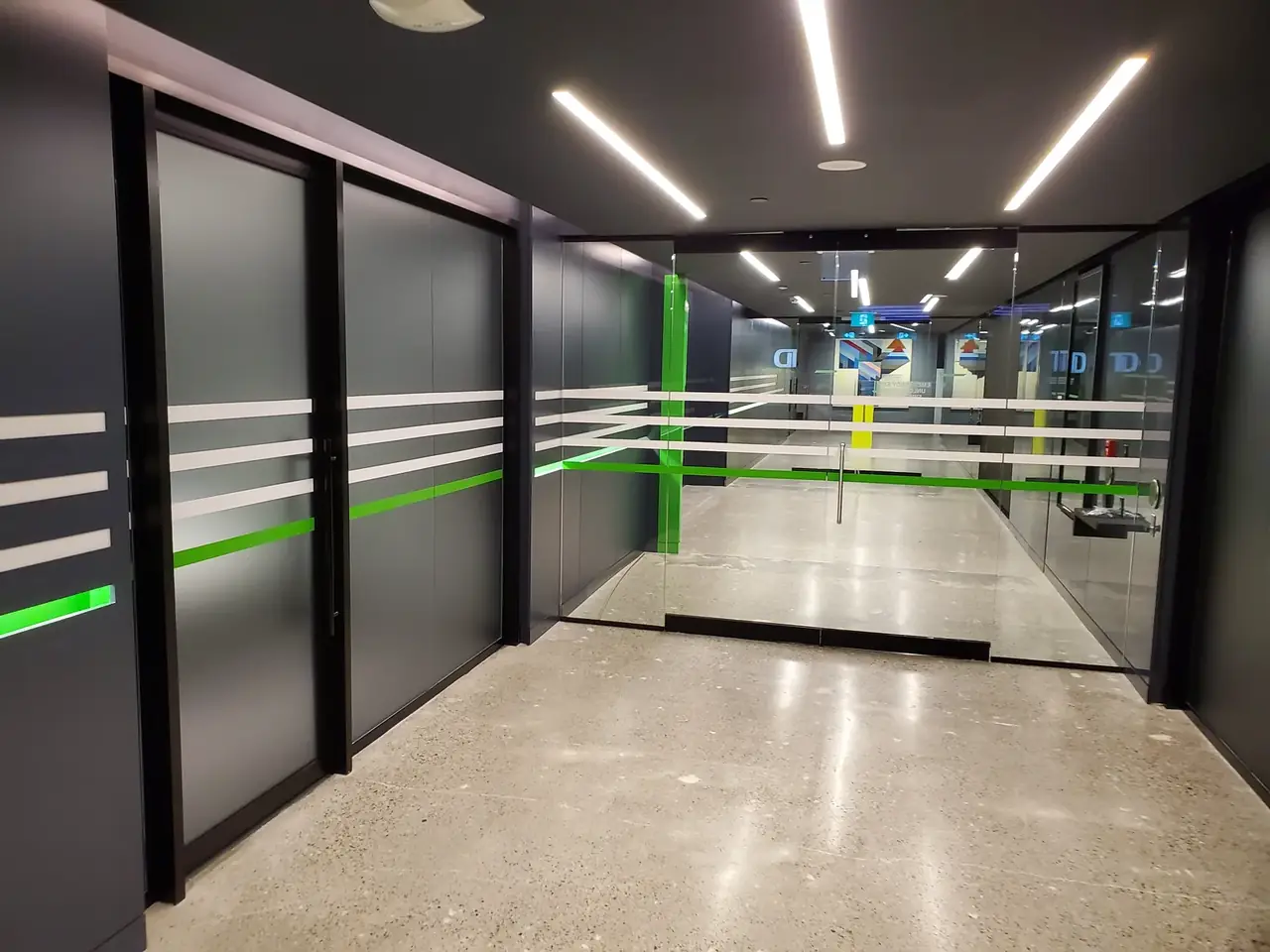 Office corridor with frosted and safety-stripe window films installed by Performance Graphics